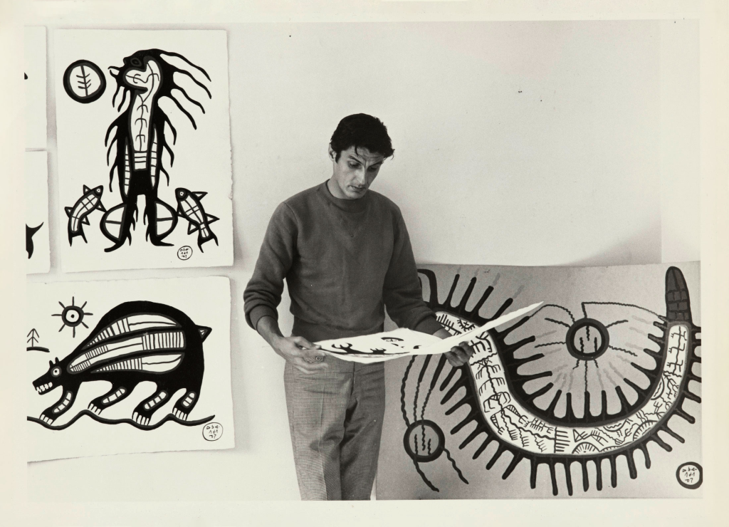A photo of Jack Pollock admiring works by Morrisseau